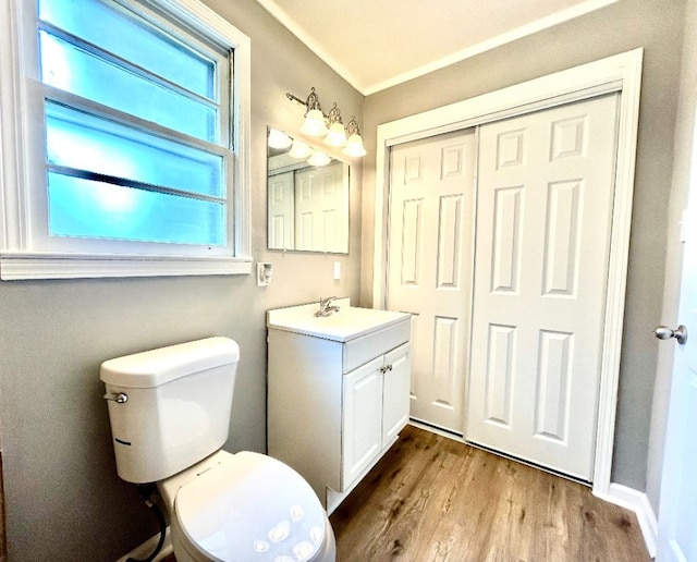 bathroom with vanity, hardwood / wood-style floors, ornamental molding, and toilet