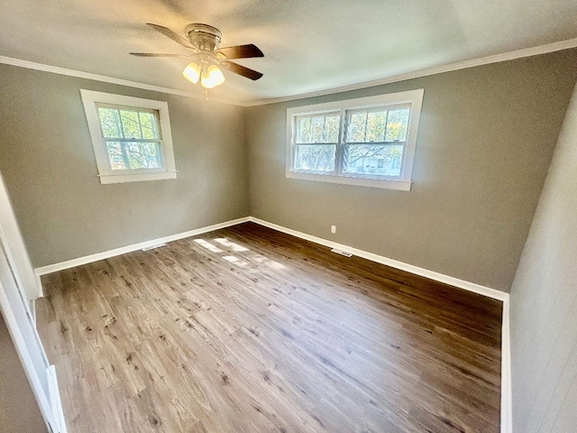 empty room with ceiling fan, wood-type flooring, and ornamental molding