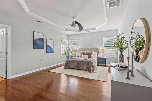 bedroom with hardwood / wood-style flooring, ceiling fan, and multiple windows