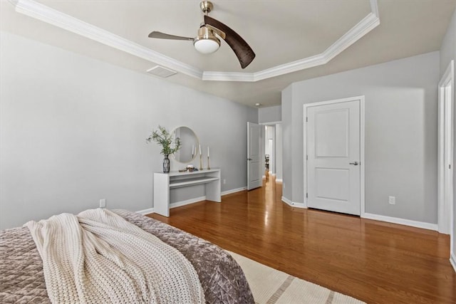 bedroom featuring a raised ceiling, ceiling fan, dark hardwood / wood-style flooring, and ornamental molding