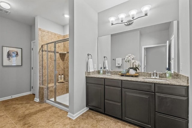 bathroom featuring tile patterned floors, a shower with door, and vanity