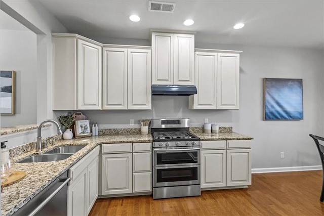 kitchen with appliances with stainless steel finishes, white cabinetry, and sink