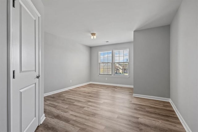 empty room with hardwood / wood-style flooring and a barn door