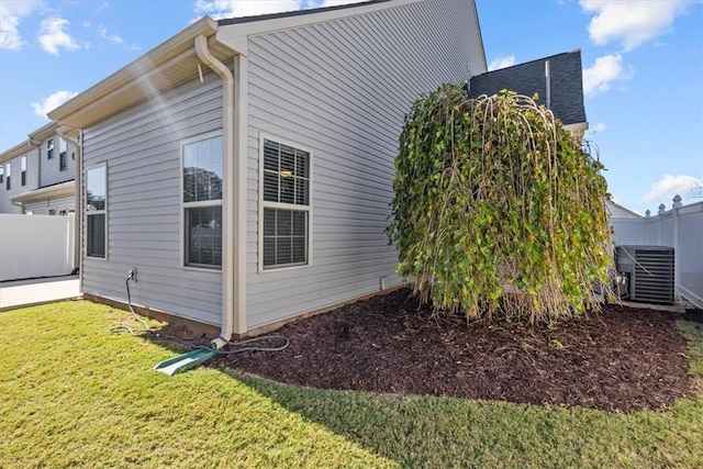 view of property exterior featuring a lawn and cooling unit