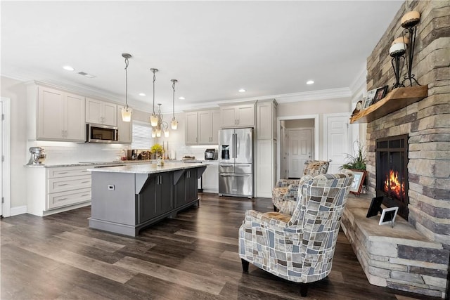 kitchen featuring stainless steel appliances, tasteful backsplash, visible vents, a kitchen island, and ornamental molding