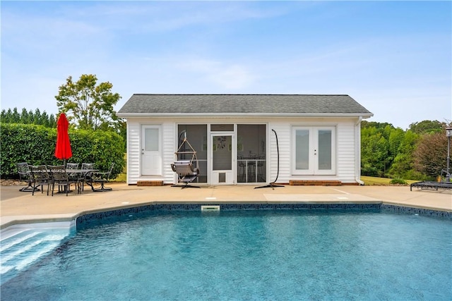 outdoor pool with an outbuilding and a patio
