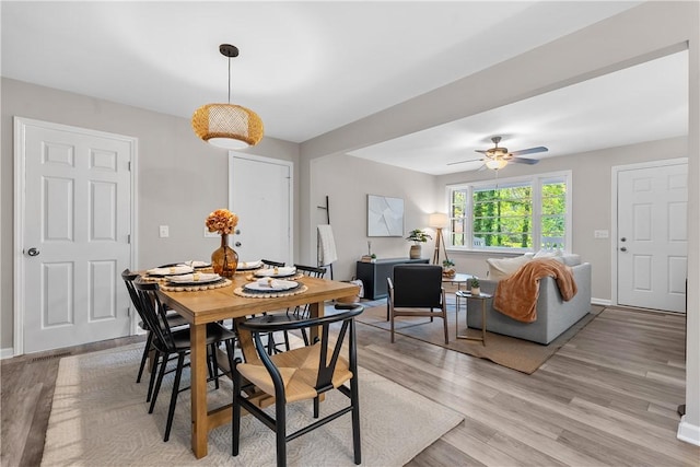 dining space with light wood-style flooring, baseboards, and ceiling fan