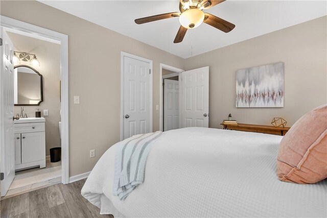 bedroom with ensuite bathroom, ceiling fan, and light hardwood / wood-style floors