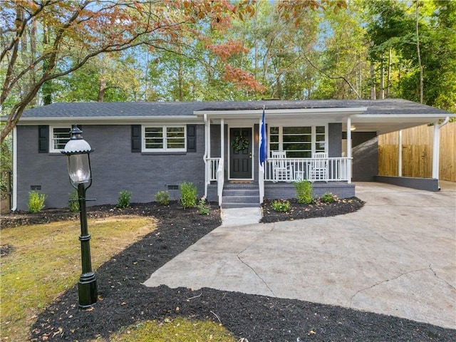 ranch-style home featuring a porch and a carport