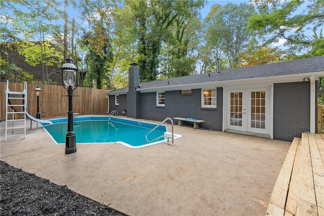 view of pool with a patio area, a water slide, and french doors