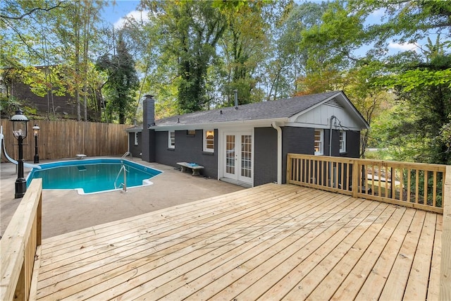 view of pool featuring a deck, a water slide, fence, french doors, and a fenced in pool