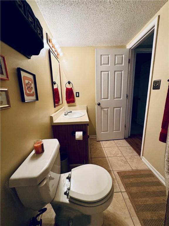 811 Northlake Dr, Anderson, SC 29625 - bathroom featuring toilet, vanity, a textured ceiling, tile patterned floors, and baseboards