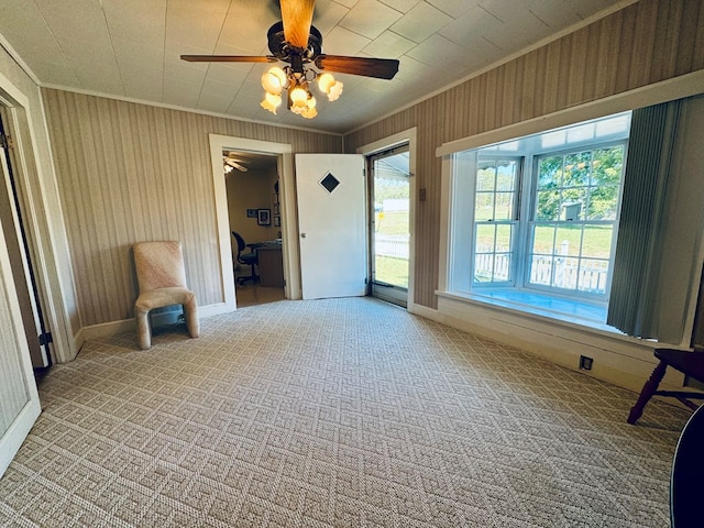 unfurnished room with crown molding, light carpet, and ceiling fan