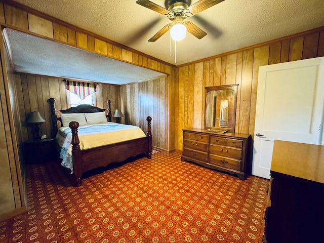 bedroom with wood walls, a textured ceiling, and ceiling fan