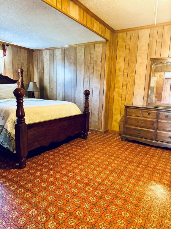 bedroom with wooden walls and a textured ceiling