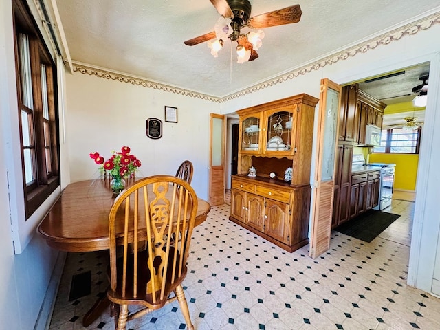 dining room with ornamental molding, a textured ceiling, and ceiling fan