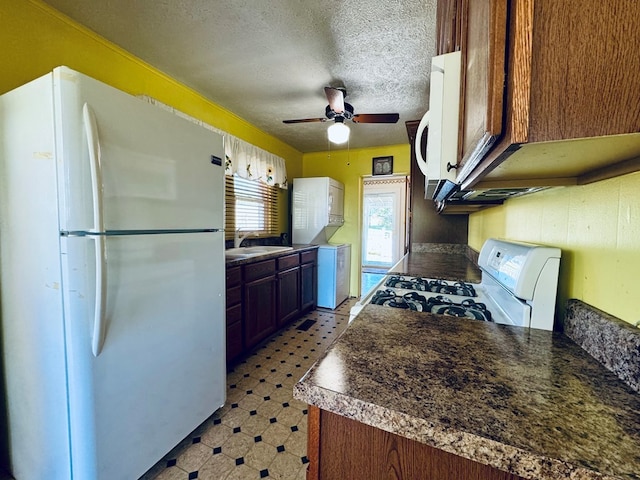 kitchen featuring white appliances, ceiling fan, a textured ceiling, and sink