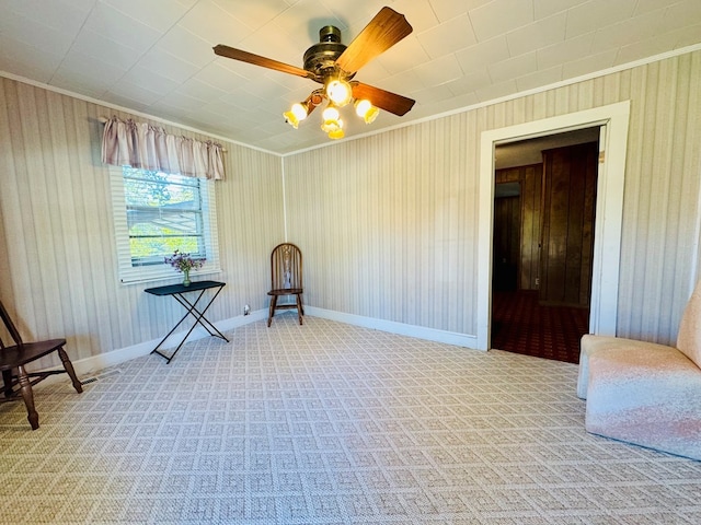 living area with ornamental molding, light colored carpet, and ceiling fan