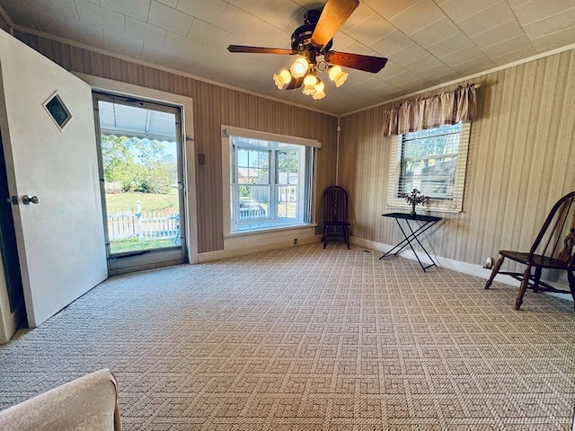 unfurnished room with ornamental molding, carpet floors, and ceiling fan