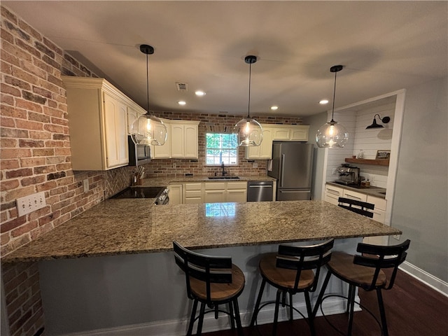 kitchen featuring sink, kitchen peninsula, stainless steel appliances, and dark hardwood / wood-style floors