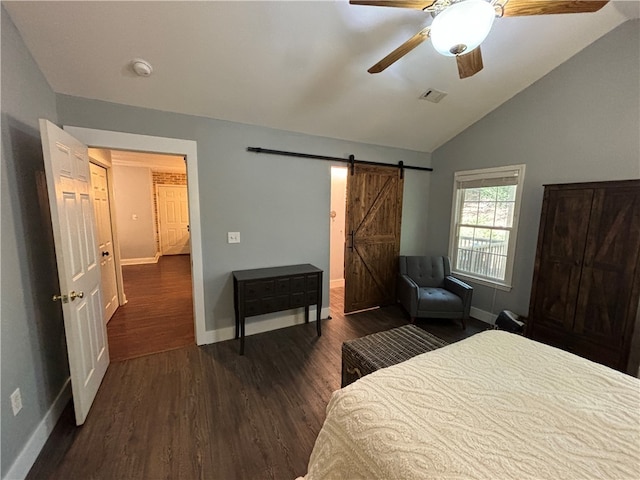 bedroom with ceiling fan, dark hardwood / wood-style floors, vaulted ceiling, and a barn door