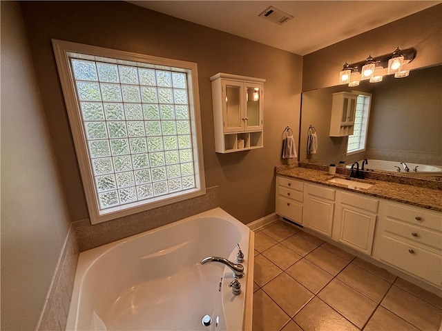 bathroom with vanity, tile patterned flooring, and a washtub