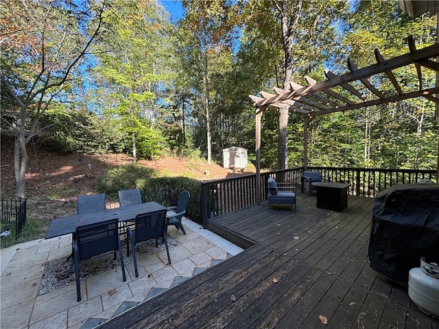 wooden terrace featuring a pergola, a patio, and a shed