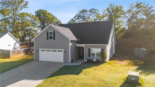 view of property featuring a garage and a front lawn