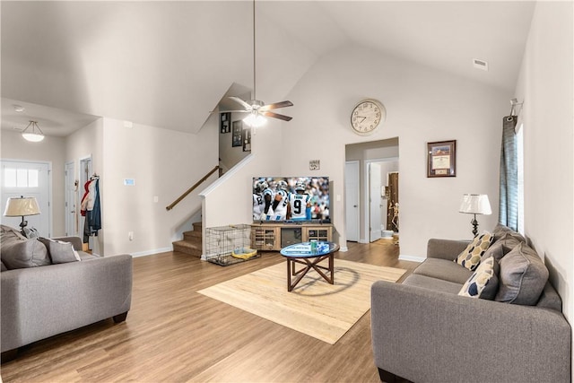 living room with a wealth of natural light, wood-type flooring, high vaulted ceiling, and ceiling fan