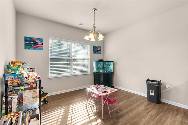 playroom with dark hardwood / wood-style flooring and an inviting chandelier