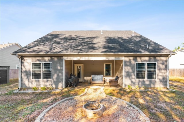 back of property with a patio and an outdoor fire pit