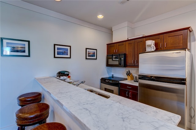 kitchen with tasteful backsplash, light stone countertops, a kitchen bar, sink, and stainless steel appliances