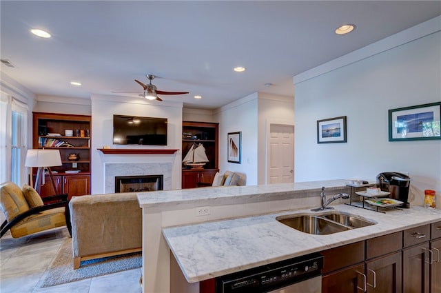 kitchen with ceiling fan, an island with sink, dishwasher, built in features, and sink