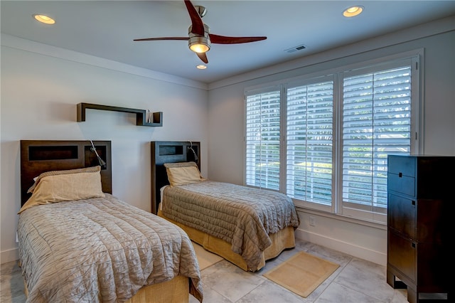 bedroom featuring multiple windows, light tile patterned floors, and ceiling fan