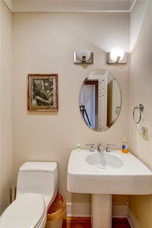 bathroom with toilet and hardwood / wood-style flooring