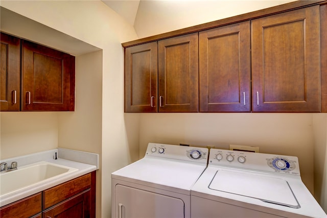 laundry room featuring sink, washer and dryer, and cabinets