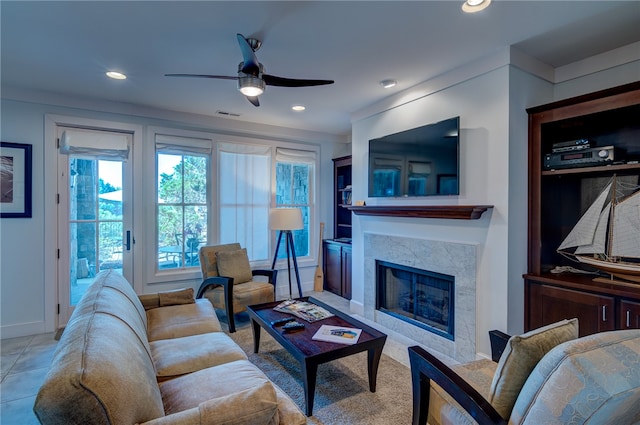 living room featuring ceiling fan and a high end fireplace