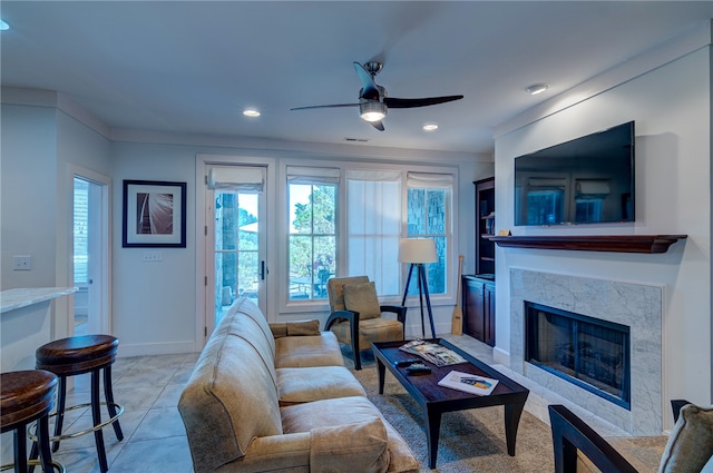 tiled living room featuring a high end fireplace and ceiling fan