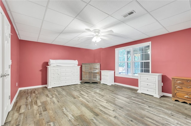 unfurnished bedroom with a drop ceiling, light hardwood / wood-style flooring, and ceiling fan