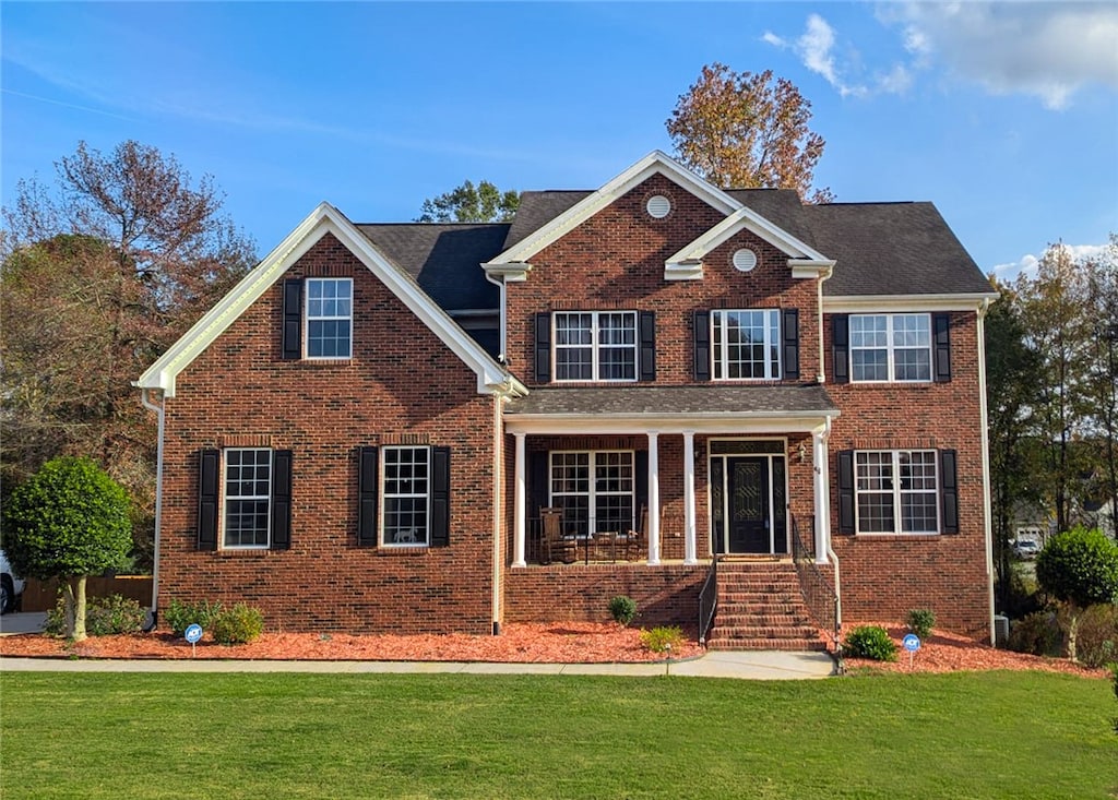 view of front of house with covered porch and a front yard