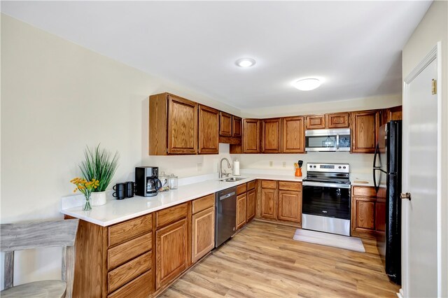 kitchen with light hardwood / wood-style floors, stainless steel appliances, and sink