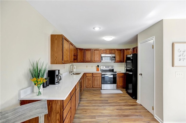 126 E Blue Heron Dr, Salem, SC 29676 - kitchen featuring appliances with stainless steel finishes, a sink, brown cabinetry, light countertops, and light wood-style flooring