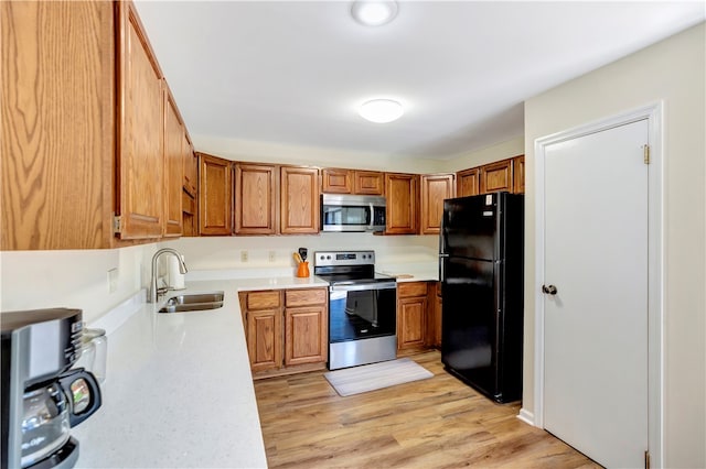 kitchen featuring light hardwood / wood-style floors, stainless steel appliances, and sink