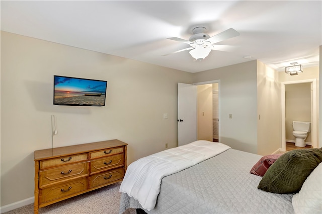 bedroom featuring connected bathroom, light carpet, and ceiling fan