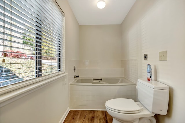 bathroom featuring toilet, wood-type flooring, and tiled tub