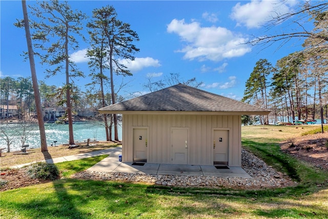 view of outdoor structure with a water view and a yard