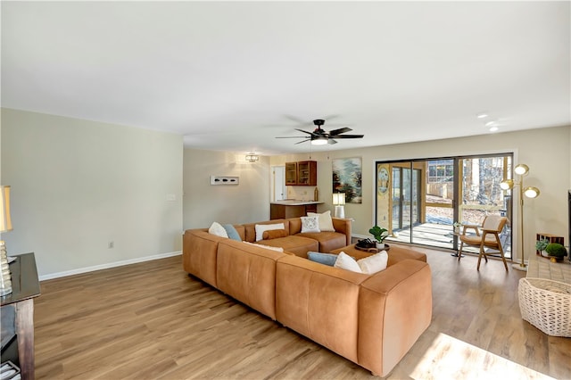 living room with light wood-type flooring and ceiling fan