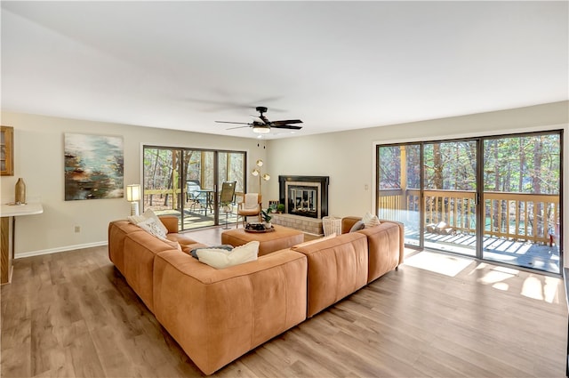 living room with light hardwood / wood-style flooring, a wealth of natural light, and ceiling fan