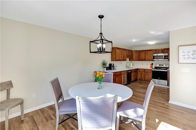 dining space with a chandelier and light hardwood / wood-style flooring