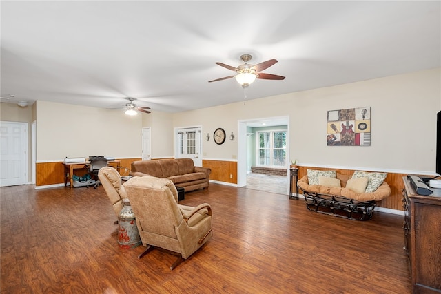 living room with ceiling fan, wooden walls, and hardwood / wood-style flooring